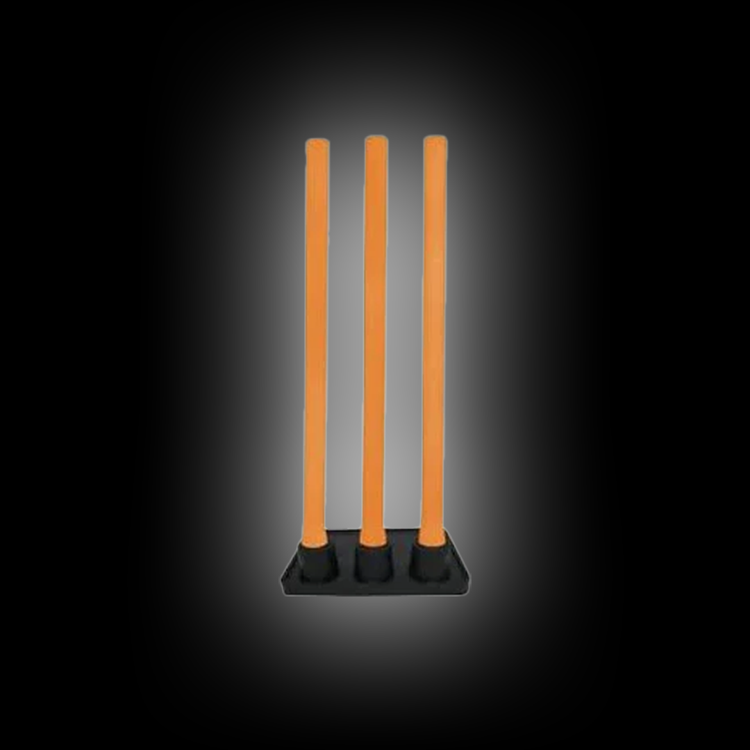 Set of three bright orange flexible cricket stumps on a black base against dark background