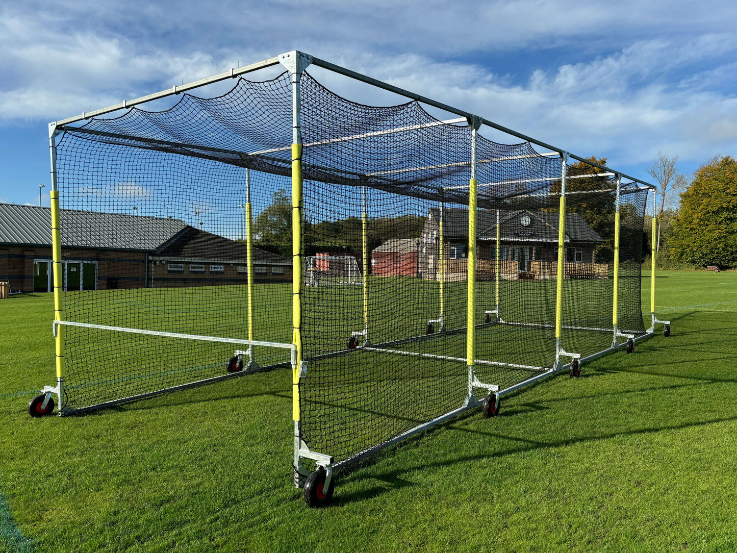 11m Anti-Vermin Mobile Batting Cage placed on a grass field with a clear sky.
