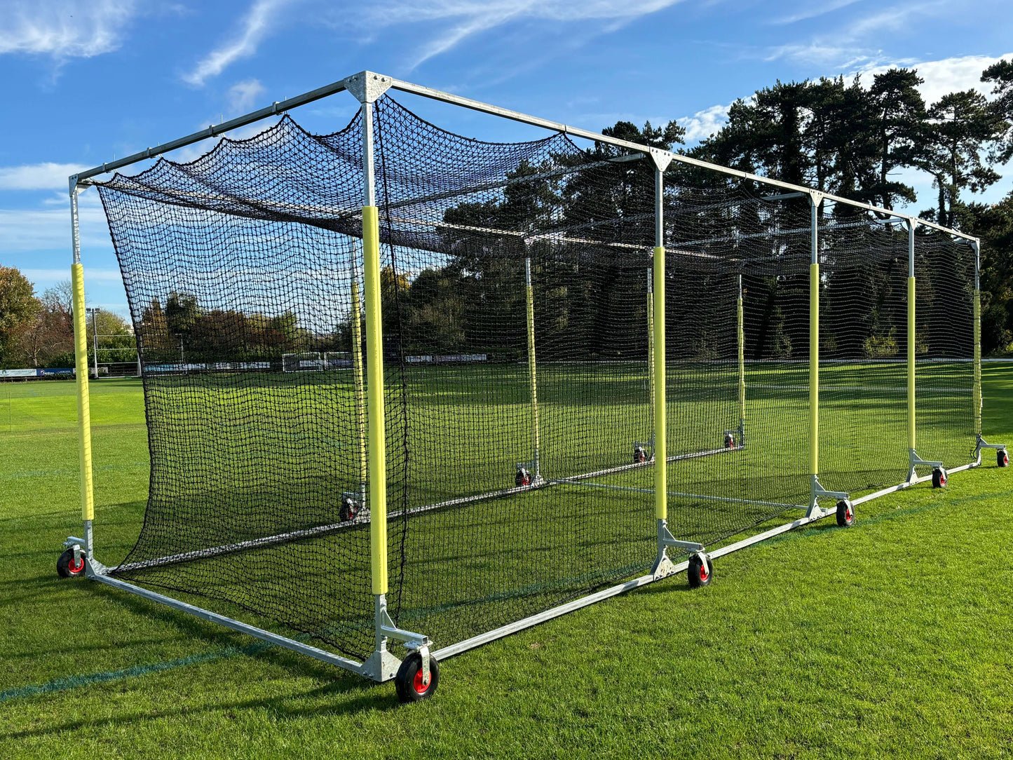 11m Anti-Vermin Mobile Batting Cage on a grassy field with clear blue sky in the background.