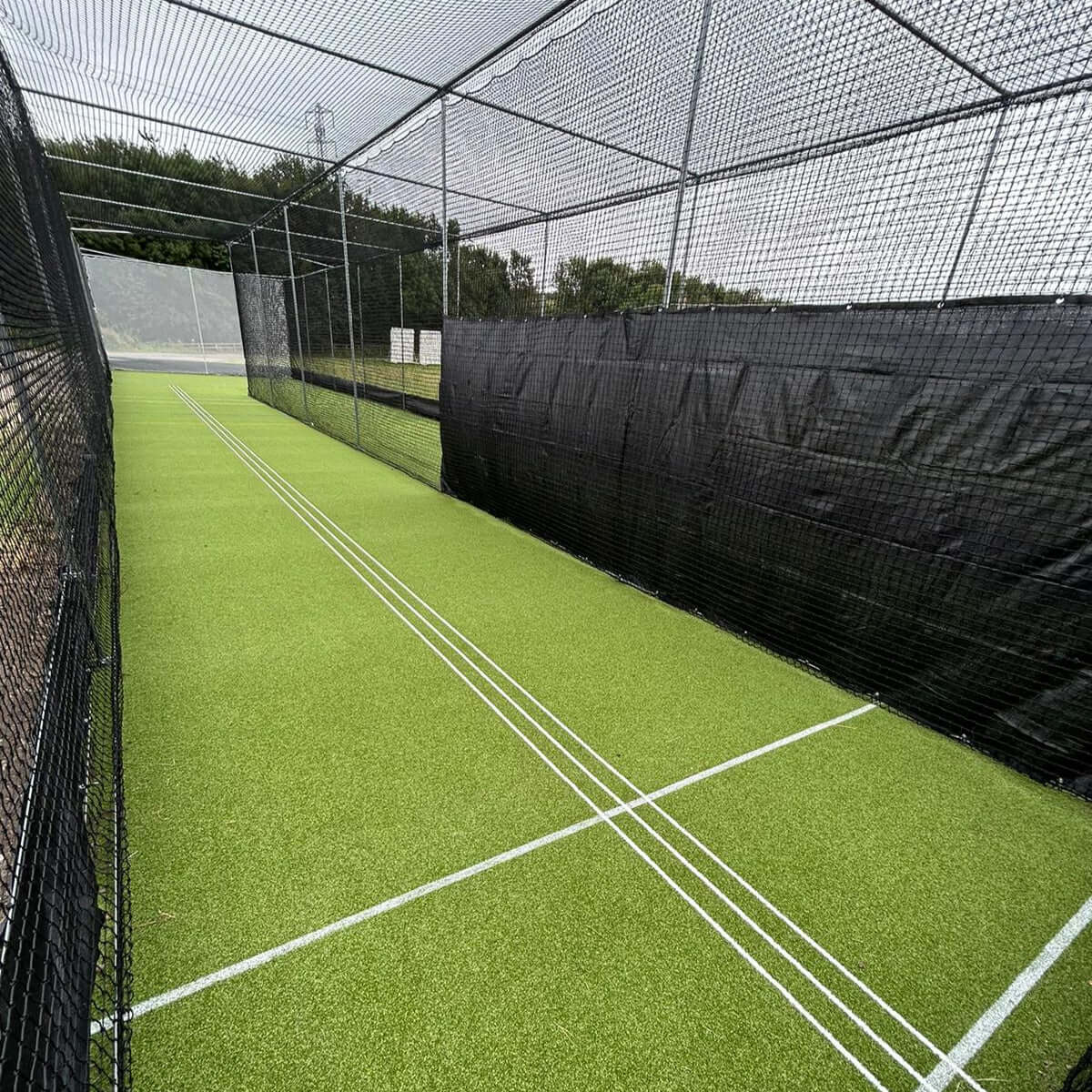 7.35m x 2m Mesh Batting Screen installed in a green cricket practice netting area.